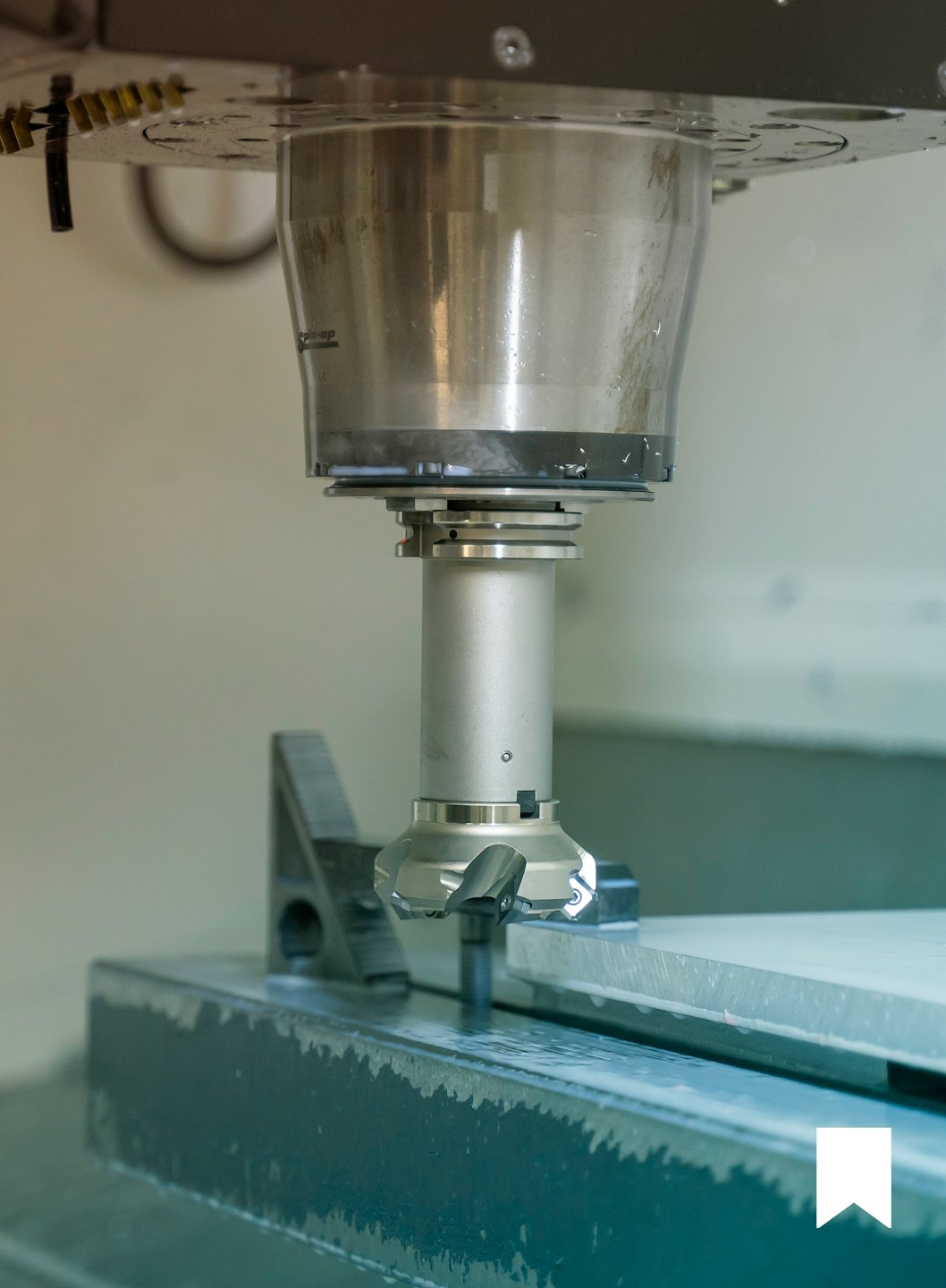 CNC milling machine cutting tool machining metal workpiece with coolant.