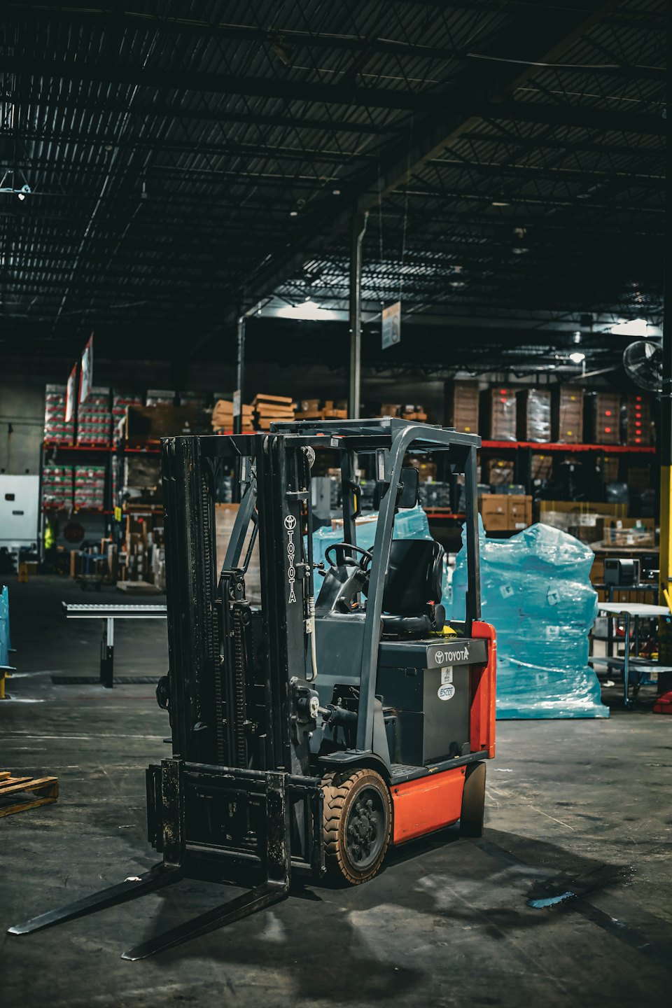 Forklift parked inside a dimly lit industrial warehouse.