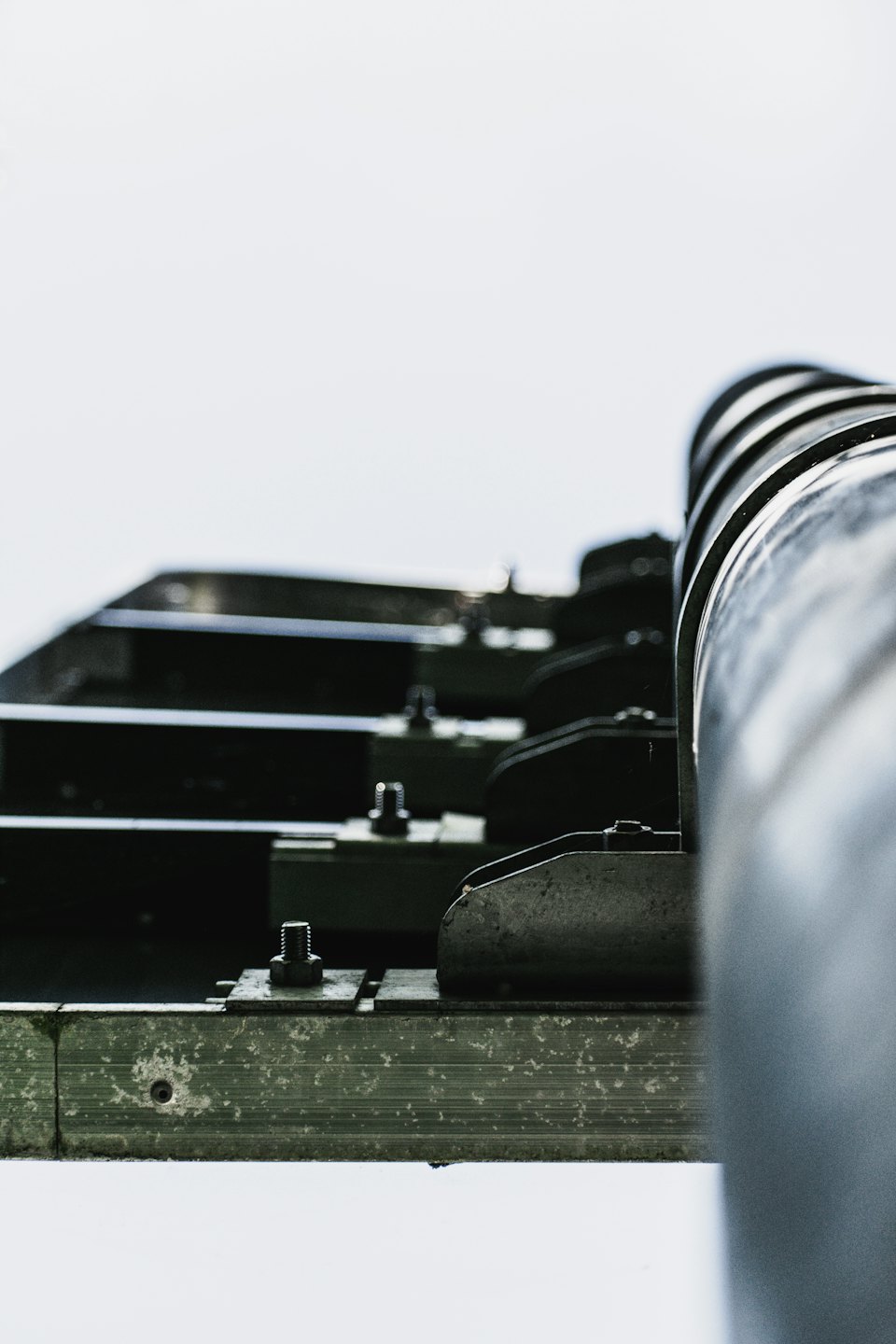 Heavy industrial machine with bolts and metal rails.