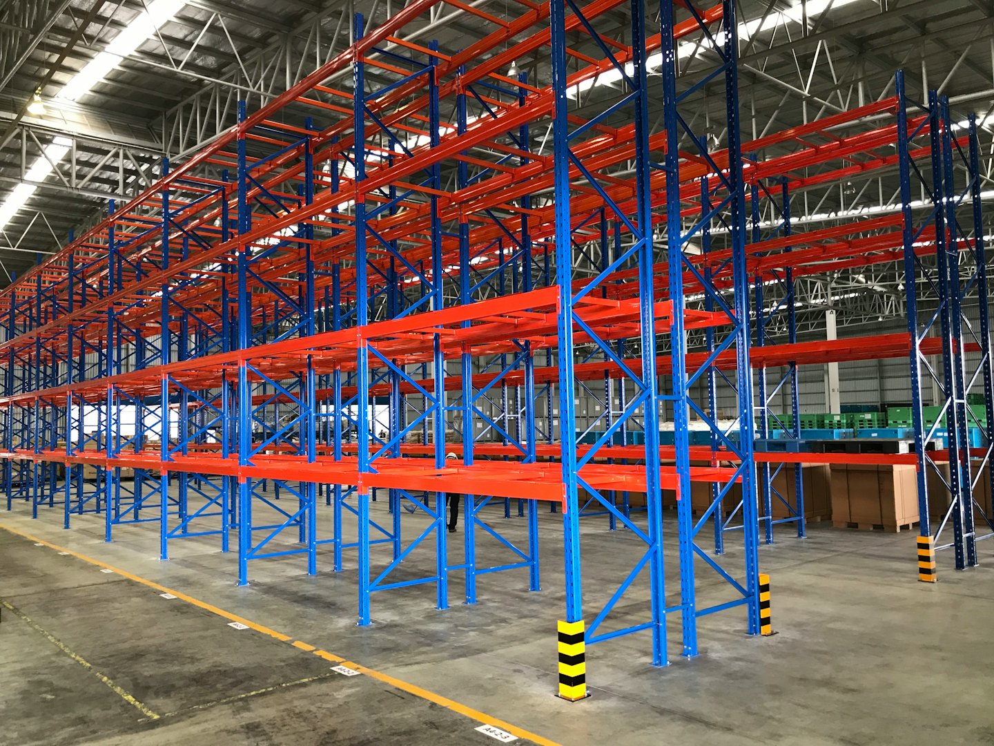 Rows of blue and orange storage racks in a large warehouse.