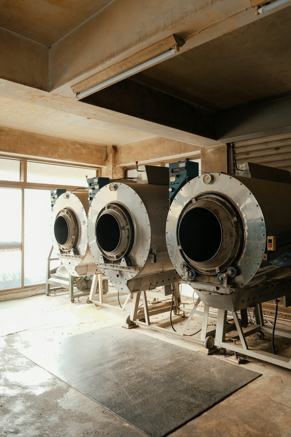 Three industrial machines lined up in a factory.